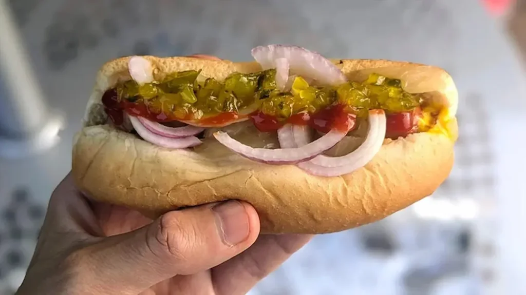 A made-to-order Sheetz hot dog on a pretzel bun with onions and Boom Boom Sauce, photographed in-store